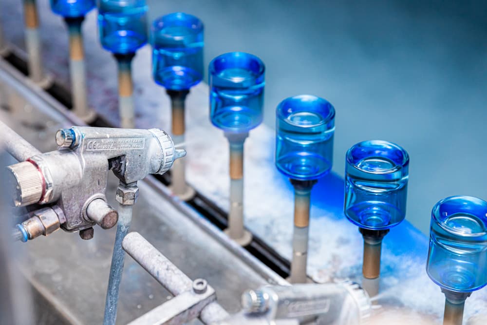 color spraying line applying a blue coating to glass bottles after annealing